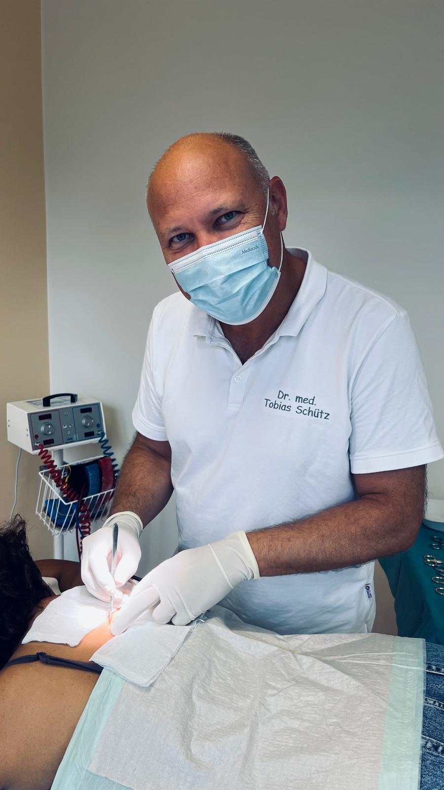 Dr. med. Tobias Schütz bei einem kleinen Eingriff im Behandlungsraum